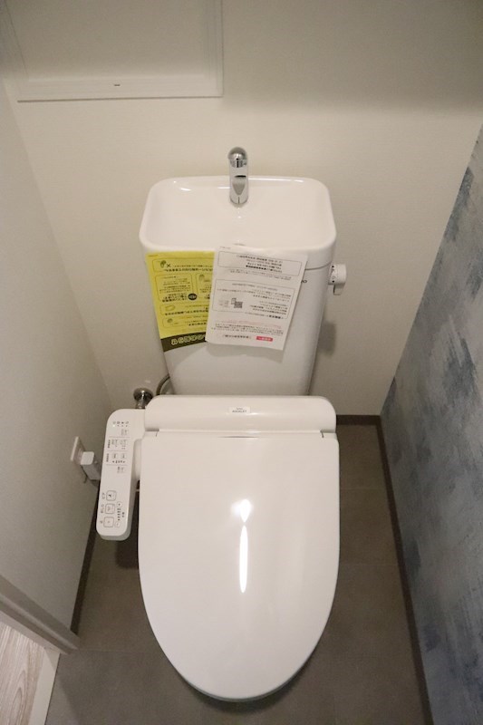 トイレ　温水洗浄便座です。トイレの上には収納棚があり、トイレを清潔に