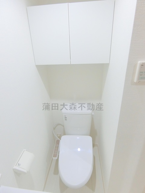 トイレ　吊戸棚収納と温水洗浄便座付きのトイレ