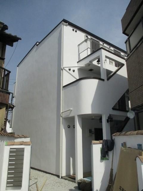 建物外観　お洒落なアプローチの先に建つ白塗りのアパート。