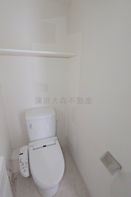 トイレ　棚と温水洗浄便座付きのトイレ