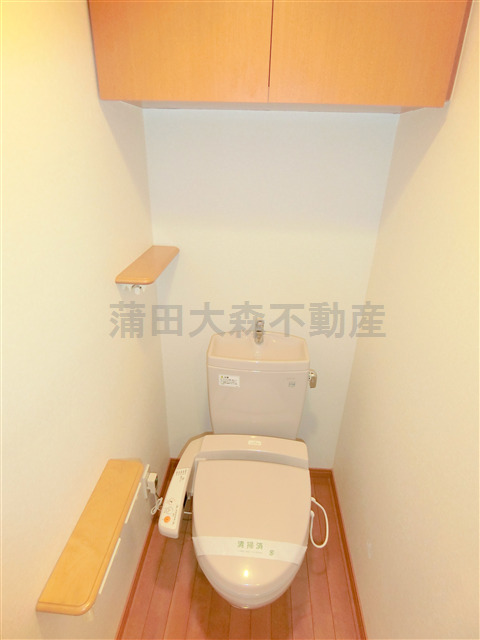 トイレ　吊戸棚と温水暖房便座付きのトイレ