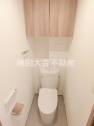 トイレ　吊戸棚収納と温水洗浄便座付きのトイレ