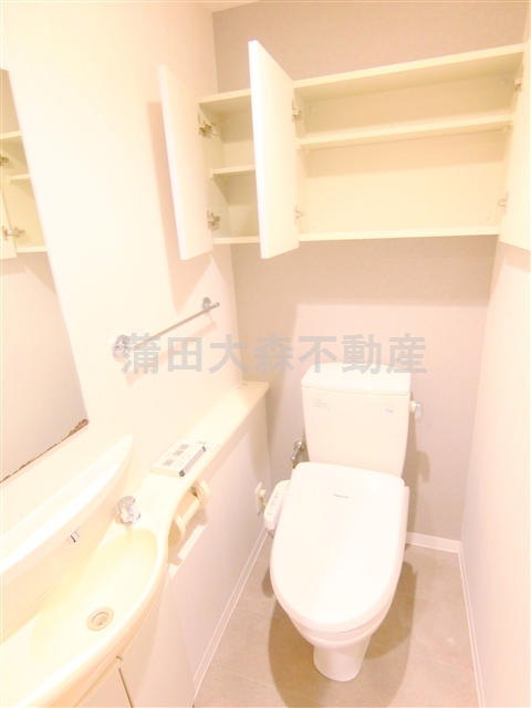 トイレ　吊戸棚と手洗い温水洗浄便座付きのトイレ
