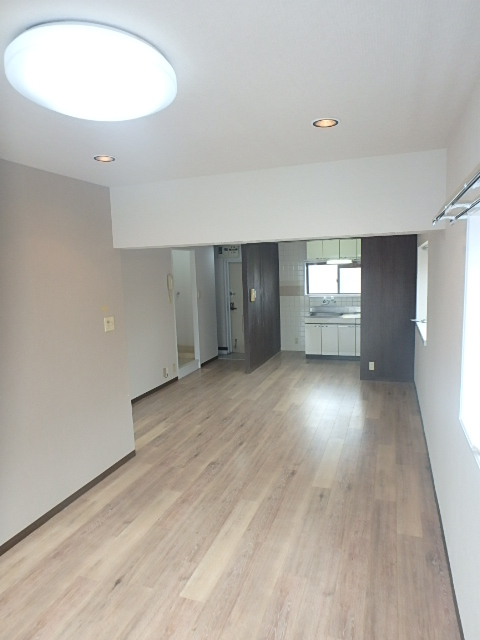 居室・リビング　無垢調の床と柱にデザインクロスをあしらった室内空間。