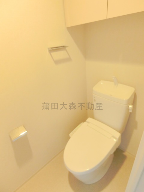 トイレ　吊戸棚収納と温水洗浄便座付きのトイレ