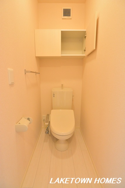 トイレ　上部に収納棚がある温水洗浄暖房便座付のトイレです。
