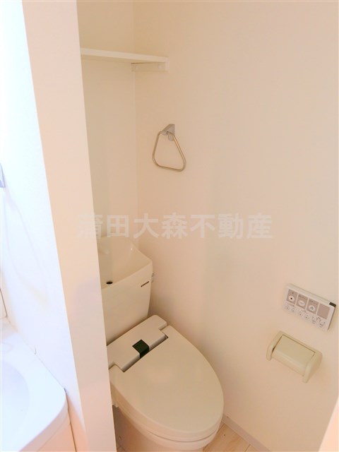 トイレ　棚と温水洗浄便座付きのトイレ