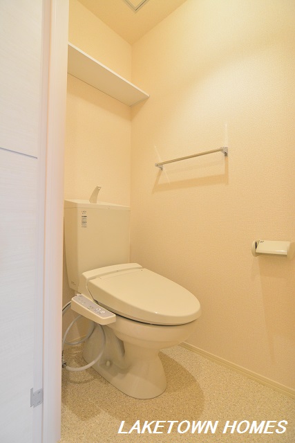 トイレ　上部に収納棚のある温水洗浄便座付のトイレです。