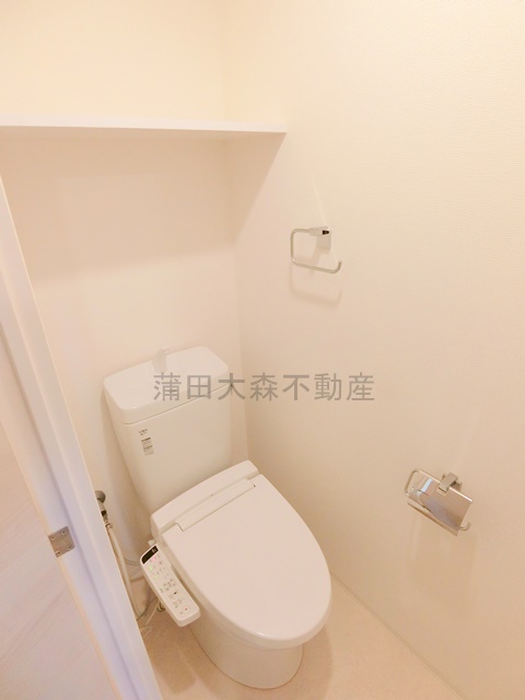トイレ　棚と温水洗浄便座付きのトイレ