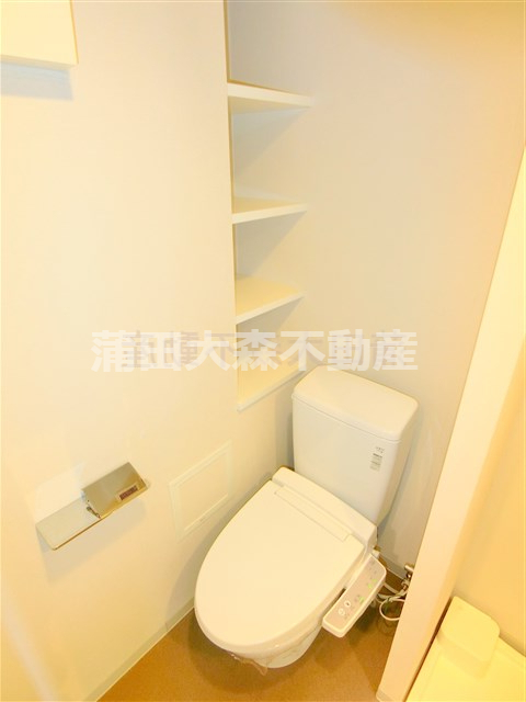 トイレ　棚と温水洗浄便座付きのトイレ