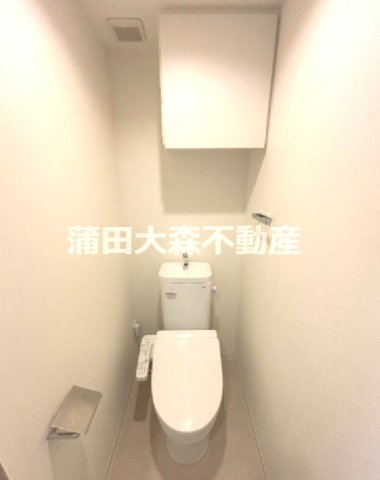 トイレ　吊戸棚と温水洗浄便座付きのトイレ