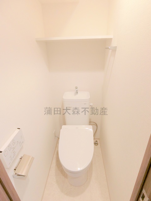 トイレ　棚と温水洗浄便座付きのトイレ