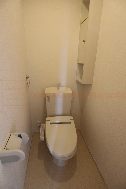 トイレ　温水洗浄便座付きのトイレは壁に収納棚があります。