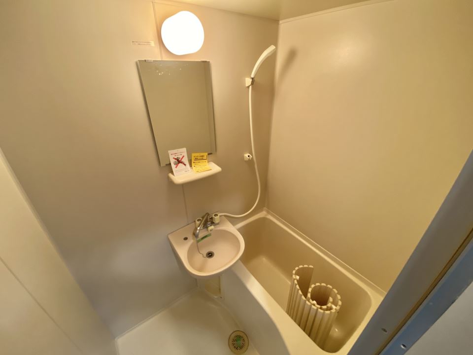 バス・シャワールーム　洗面台と鏡付きのバスルームです