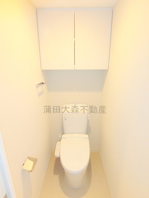 トイレ　吊戸棚収納と温水洗浄便座付きのトイレ