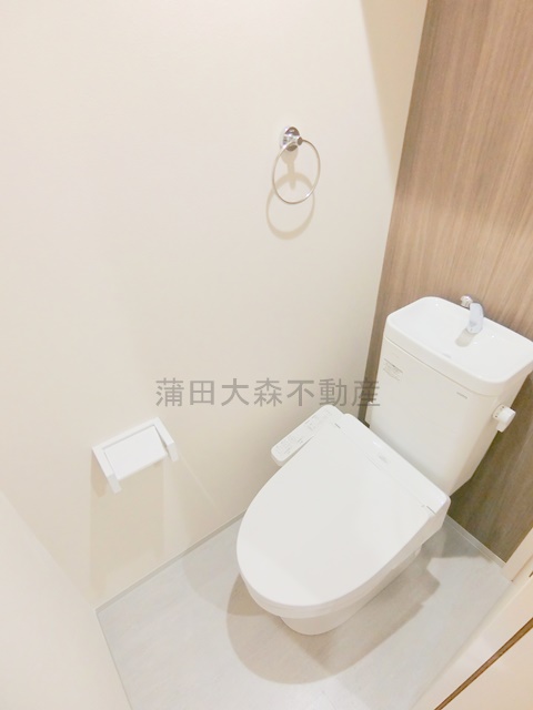 トイレ　棚と温水洗浄便座付きのトイレ