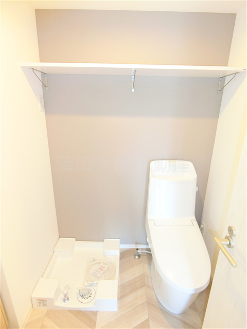 トイレ　棚と温水洗浄便座付きのトイレ