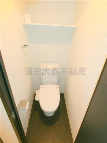 トイレ　棚と温水暖房便座付きのトイレ
