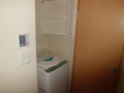その他設備　洗濯機。洗剤を置くのに便利な棚が横にあります。