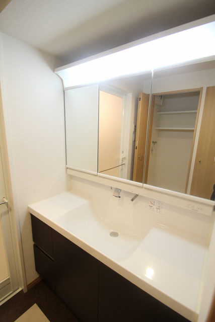 洗面設備　洗面台。三面鏡の広々とした洗面台です。