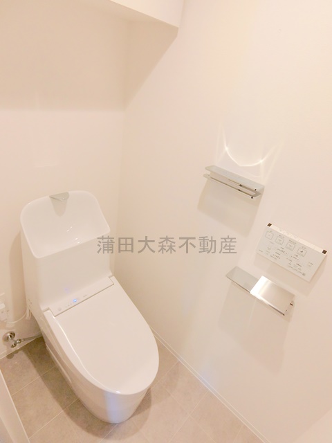 トイレ　棚と温水洗浄便座付きのトイレ