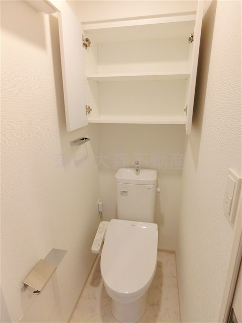 トイレ　棚収納に温水暖房付のトイレ