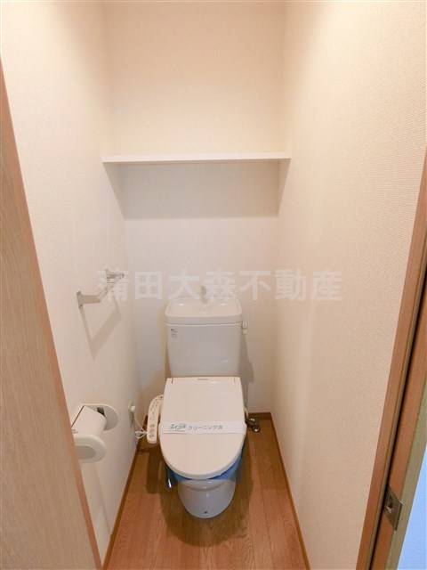 トイレ　棚と温水暖房便座付きのトイレ
