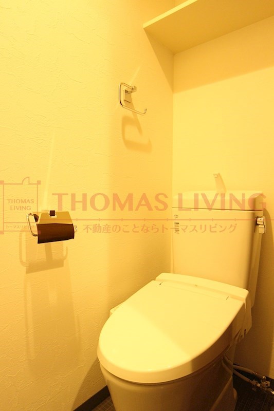 トイレ　温水洗浄便座。上部には棚も備え付け。(写真はウッド系フローリ