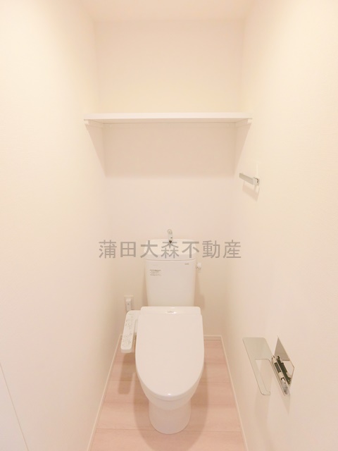 トイレ　棚と温水洗浄便座付きのトイレ