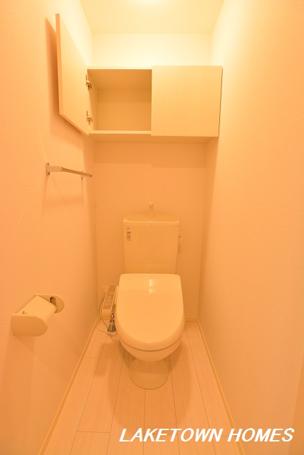 トイレ　上部に収納棚がある温水洗浄暖房便座付のトイレです。