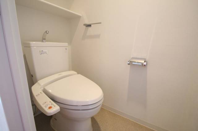 トイレ　ウォシュレットや収納棚のついたトイレ　１４０２号室の写真です