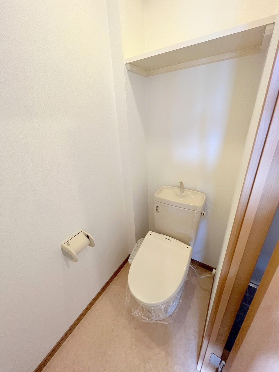 トイレ　ウォシュレット付きトイレ。上部には便利な棚もあります。
