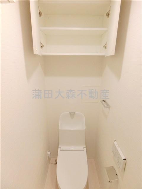 トイレ　吊り戸棚収納と温水洗浄便座付きのトイレ