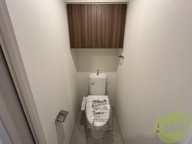 トイレ　トイレには温水洗浄便座がついています。上段に棚もありますね。