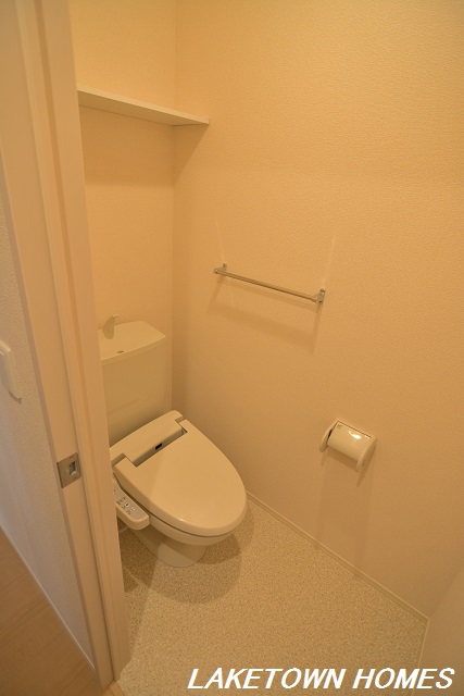 トイレ　上部に収納棚のある温水洗浄便座付のトイレです。