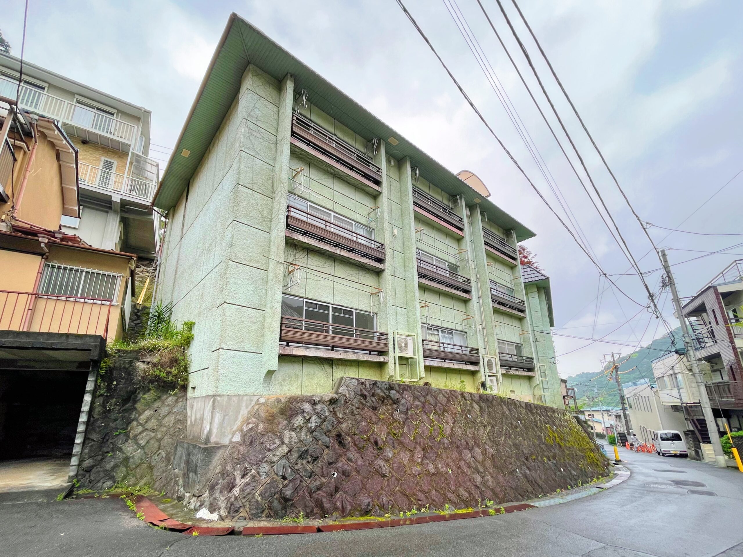 建物外観　高台に建つマンション。淡いグリーンの外壁が、個性的でかわいい