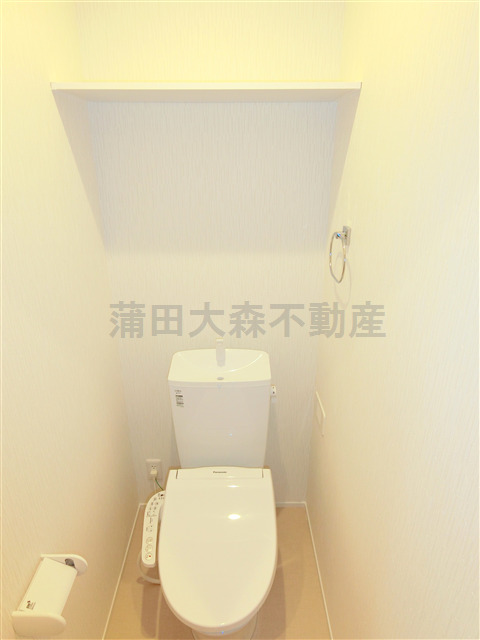 トイレ　棚と温水洗浄便座付きのトイレ
