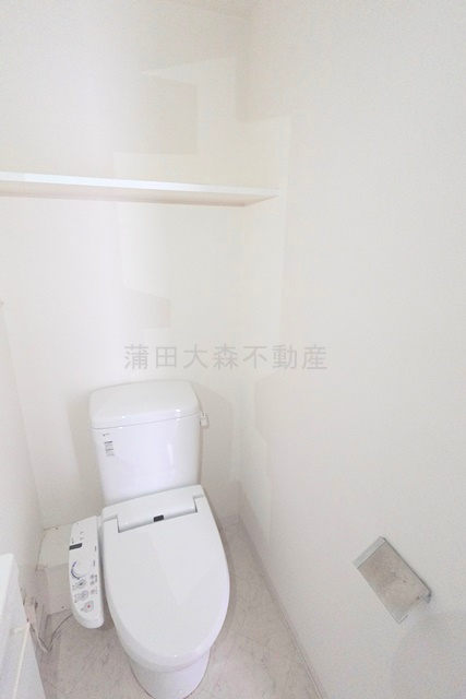 トイレ　棚と温水洗浄便座付きのトイレ