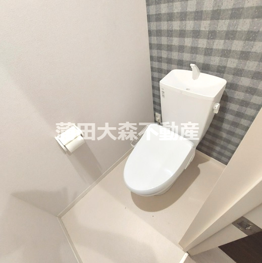 トイレ　棚と温水洗浄便座付きのトイレ