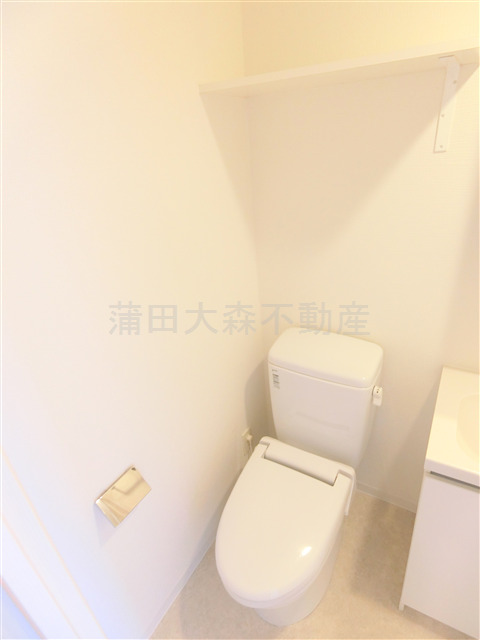 トイレ　棚と温水暖房便座付きのトイレ