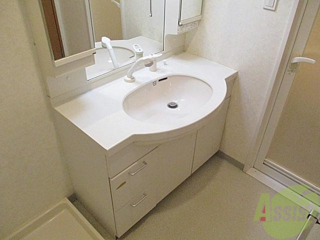 洗面設備　左右に幅のあるシャンドレ付の洗面台。ちょっと物を置くにも便利