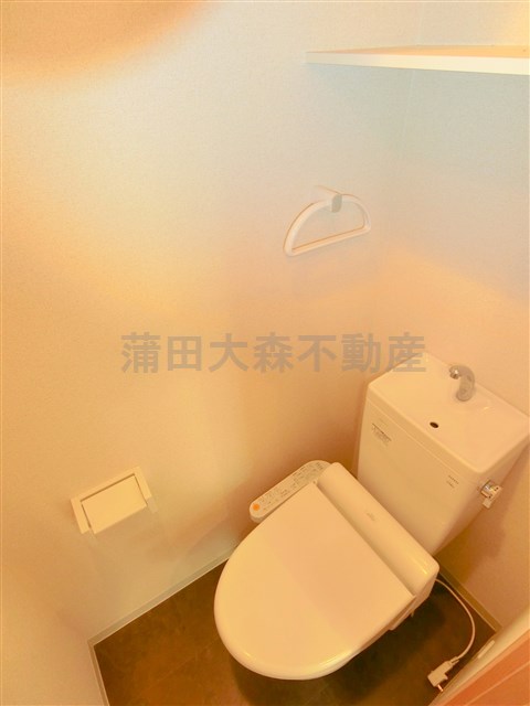 トイレ　棚と温水洗浄暖房便座付きのトイレ