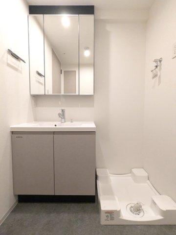 洗面設備　トイレと独立した三面鏡付・ハンドシャワー付洗面台、洗濯機置場