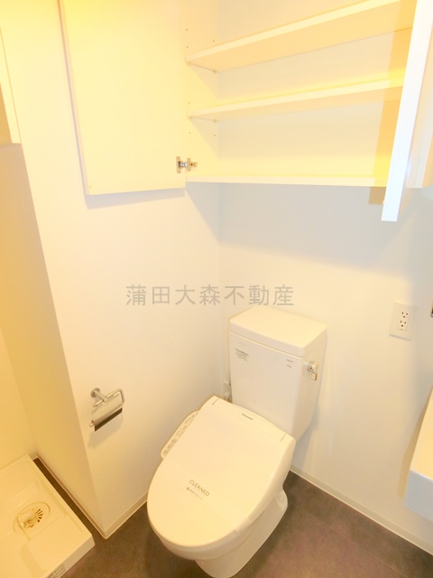 トイレ　吊戸棚収納と温水洗浄便座付きのトイレ
