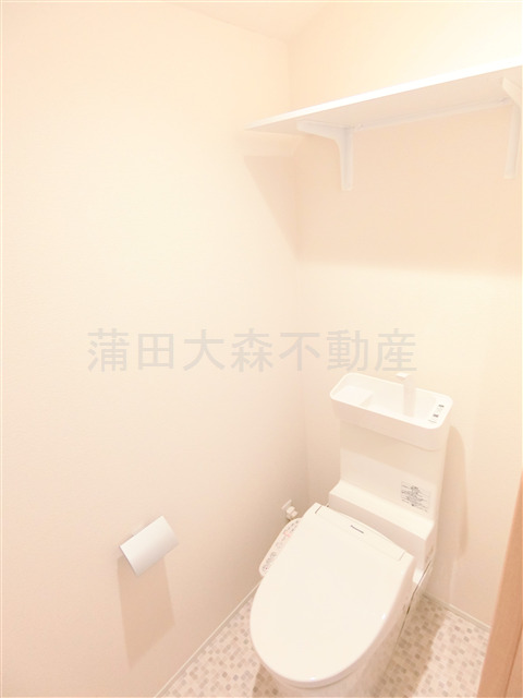 トイレ　棚と温水洗浄便座付きのトイレ