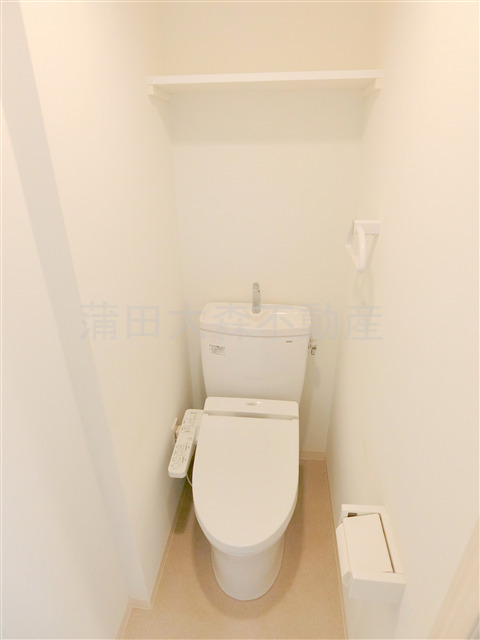 トイレ　棚と温水洗浄便座付きのトイレ