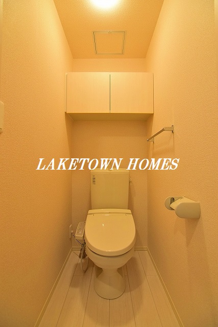 トイレ　上部に収納棚のある温水洗浄便座付のトイレです。