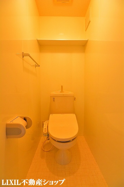 トイレ　上部に収納棚のある温水洗浄便座付のトイレです。