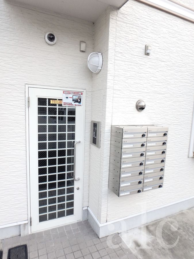 エントランス　オートロックエントランス。上部には24時間稼働の防犯カメラが