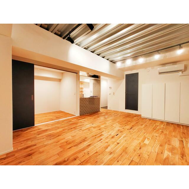 居室・リビング　木目の床と開放的な天井が魅力の広々空間。スライド扉で生活シー